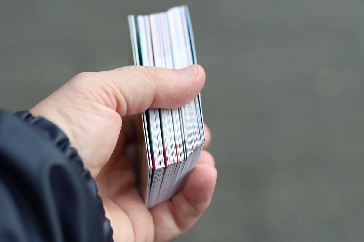 A hand holding a fresh pack of trading cards