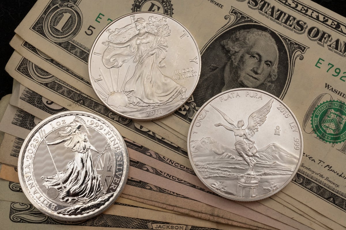 International silver coins displayed beside a banknote