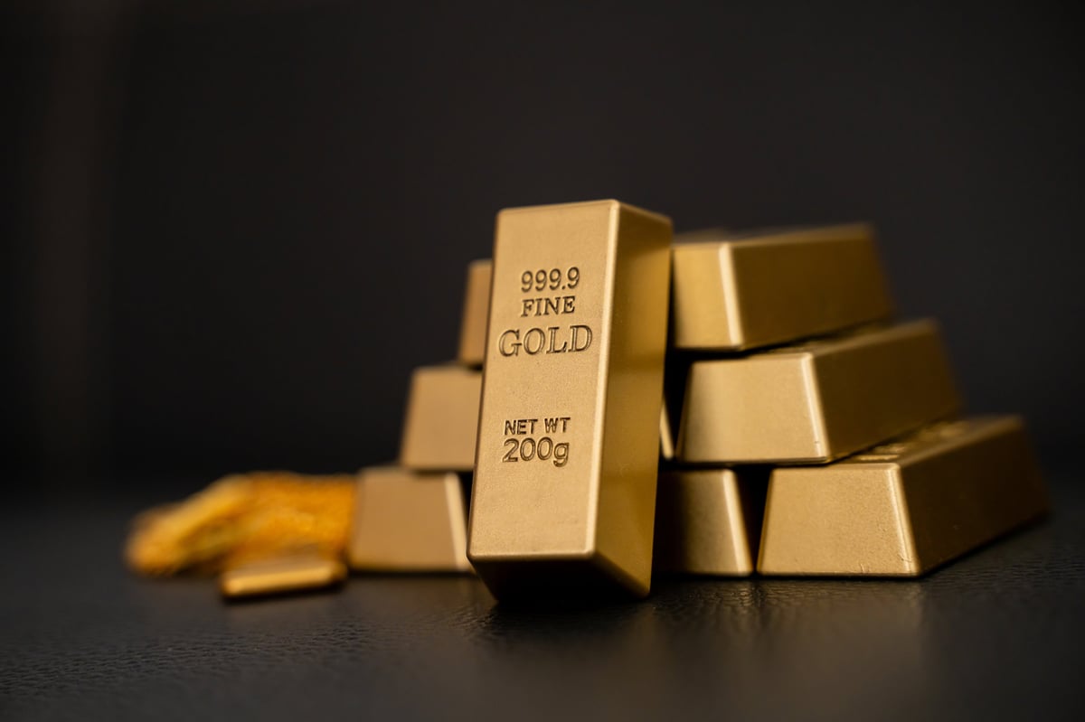 Stacked fine gold bullion bars on a dark background