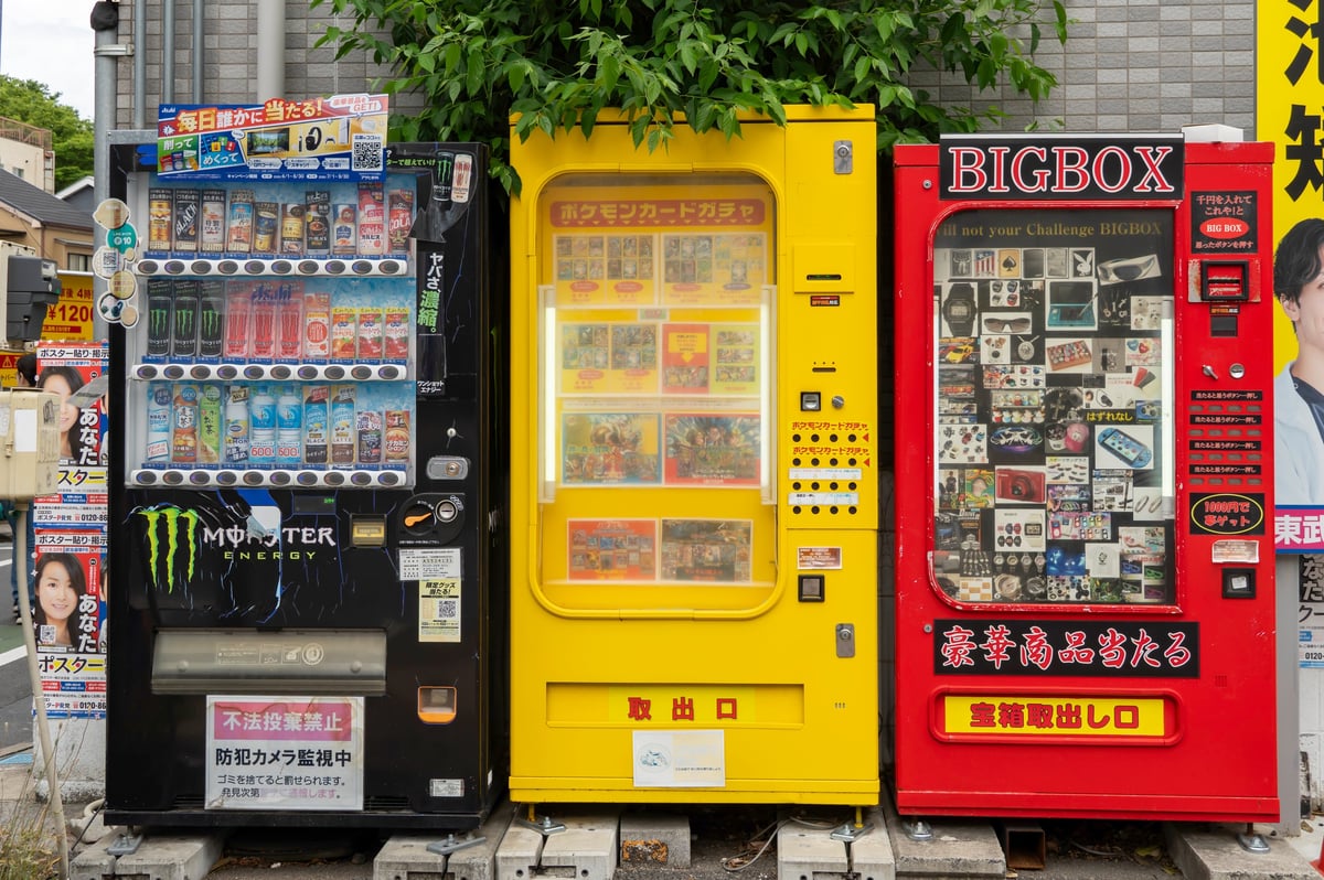 A Pokemon trading card dispenser and vending machines on a Tokyo street